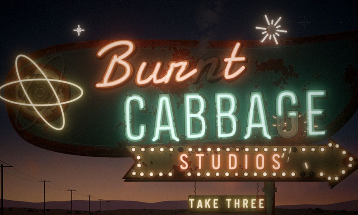 Burnt Cabbage Studios, Take Three. A neon retro motel sign at dusk in the desert.